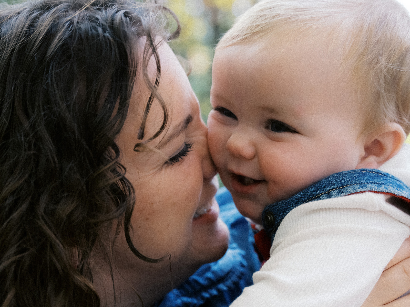 A mother kissing her smiling baby